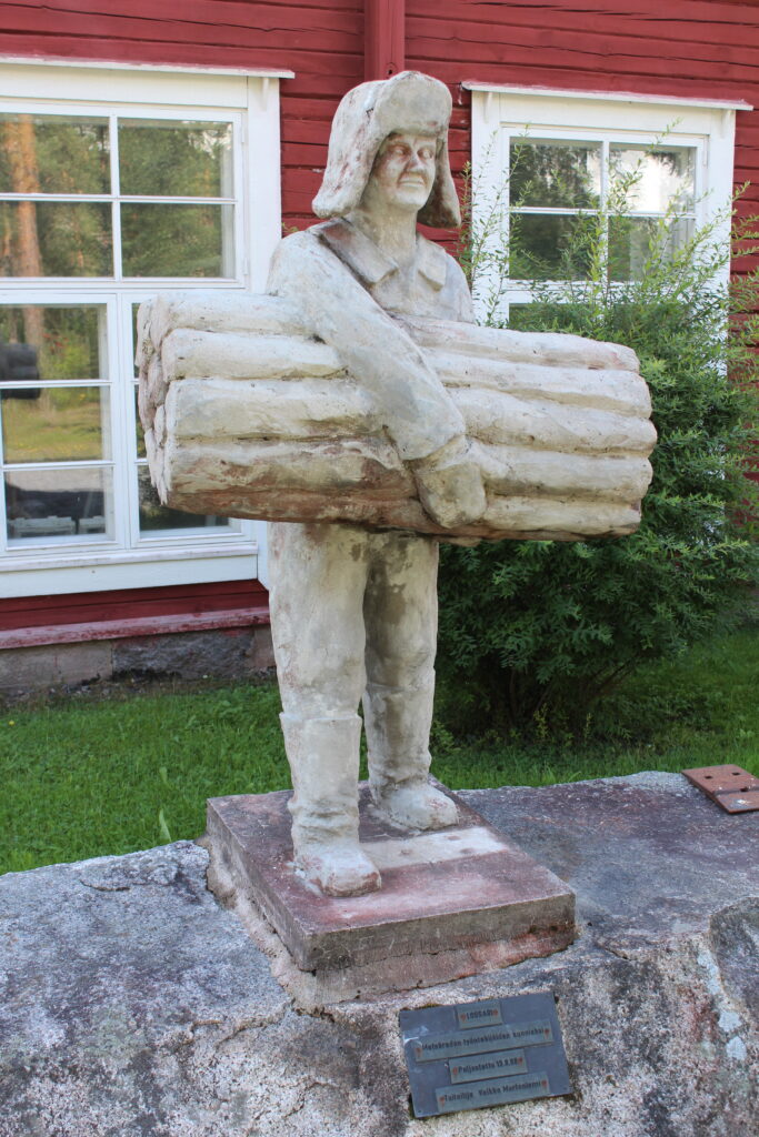 Metsätyömiestä esittävä puinen patsas.
