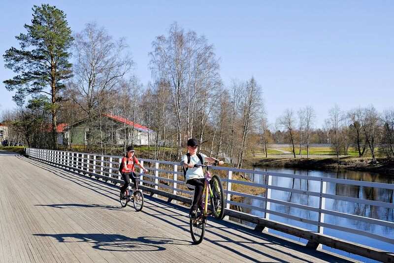 Kaksi pyöräilijää sillalla.