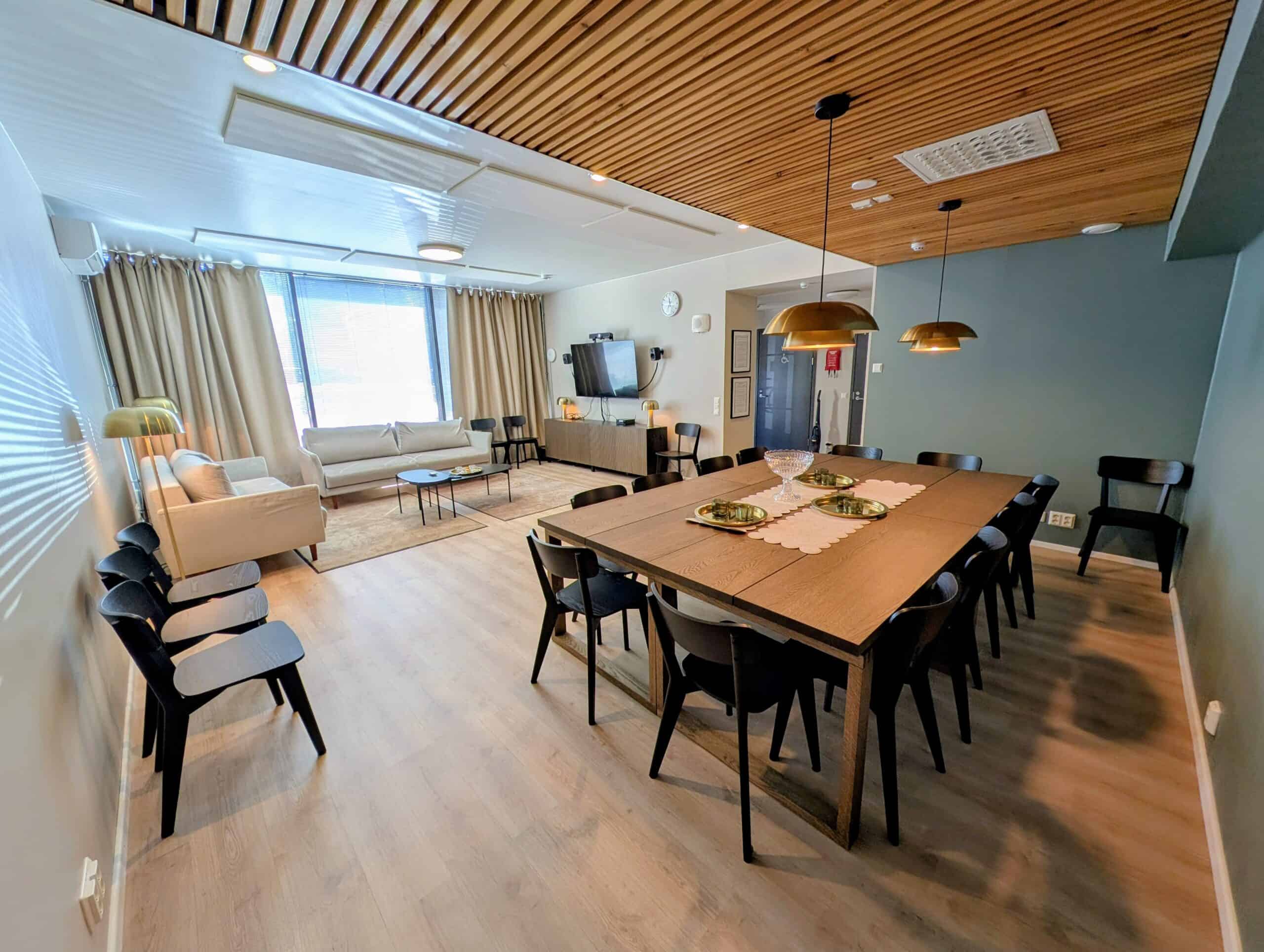 Kabinetti jossa pöytiä, televisio ja sohvia.